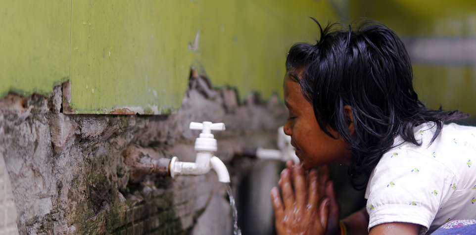 Image of young girl in Bangladesh washing her face